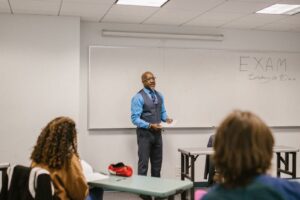 Professor giving a lecture to diverse students in a university classroom setting.